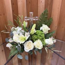 White floral arrangement with a clear cross centerpiece