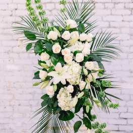 White floral standing spray with roses, lilies, and greenery