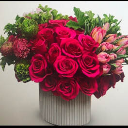 Bouquet of hot pink roses and pink tulips in a ribbed white vase