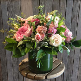 Pink and cream rose bouquet in a green vase