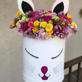 Flower arrangement in a white cat-face box with pink ears