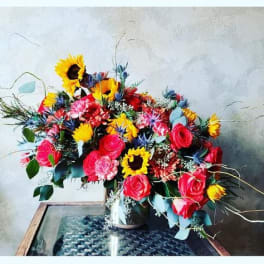 Bright mixed bouquet with sunflowers and pink roses in a vase