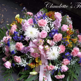 Large pink and white floral casket spray with ribbon