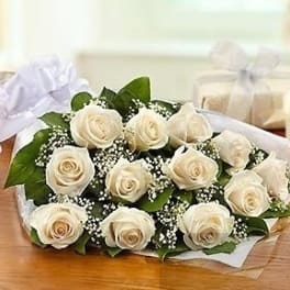 Bouquet of white roses with baby's breath wrapped in white paper