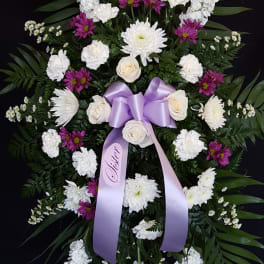 Standing floral spray with white and purple flowers and a lavender ribbon