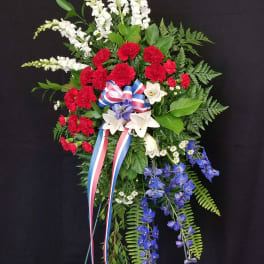 Standing floral spray with red, white, and blue flowers on a black background