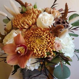 Autumn bouquet with orange chrysanthemums, white roses, and an orchid in a wooden box