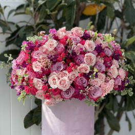 Pink and lavender rose arrangement in a pastel round box