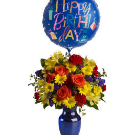 Birthday balloon above a mixed flower bouquet in a blue vase