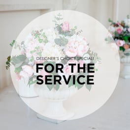 Pink and white floral arrangement in a white pedestal vase