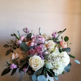 Bouquet of white, pink, and peach flowers in a decorative vase