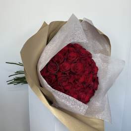 Bouquet of red roses wrapped in brown and white paper