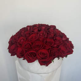 Round arrangement of red roses in a white hat box