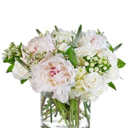 White and blush bouquet in a clear glass vase