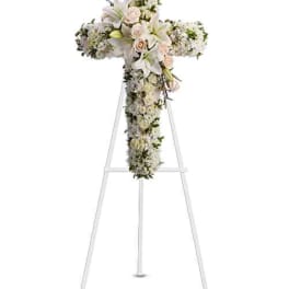 White floral cross arrangement on a stand