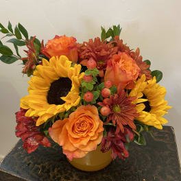 Orange and yellow mixed bouquet in a yellow vase