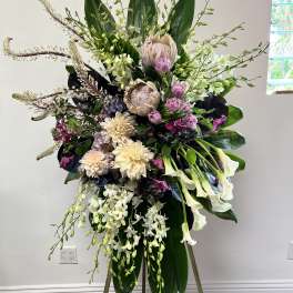 Tall floral standing spray with white orchids, calla lilies, and pink blooms