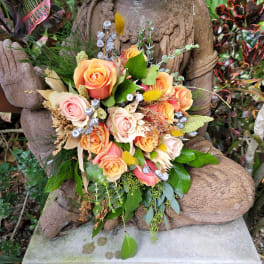 Bouquet of peach and pink roses with mixed greenery and dried accents