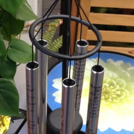 Metal wind chime with a stained-glass flower ornament