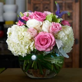 Pink and white roses with hydrangeas in a glass vase