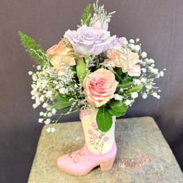 Bouquet of pastel roses in a pink decorative boot vase