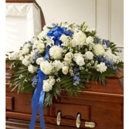 White and blue funeral spray on a casket with ribbon