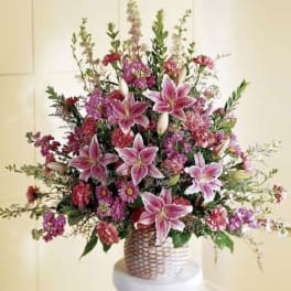 Large bouquet of pink lilies and mixed flowers in a woven basket