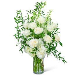 White roses and hydrangeas in a clear glass vase