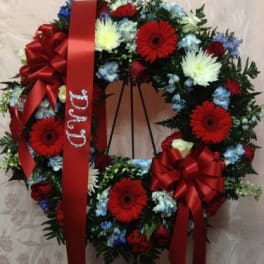 Red and blue floral wreath with ribbon on a stand
