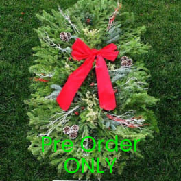 Holiday wreath with a red bow and pinecones on a green background
