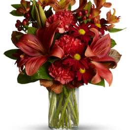 Red and orange mixed bouquet in a clear glass vase