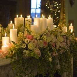 Floral centerpiece with white candles and pale roses