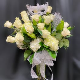 Cream roses and white hydrangeas in a glass vase with a silver mask topper