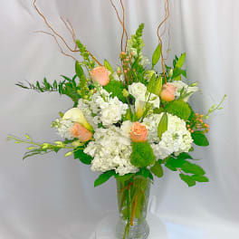 White and peach floral arrangement in a clear glass vase