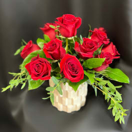 Red roses arranged in a cream textured vase