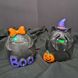 Two black Halloween cat figurines with a bow and witch hat