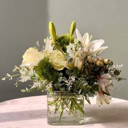 White lilies and roses in a clear glass vase