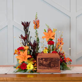 Autumn floral arrangement with lilies, snapdragons, and mums around a wooden box