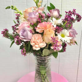Pastel mixed flower bouquet in a clear glass vase