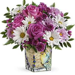 Pink roses and white daisies in a decorative square vase