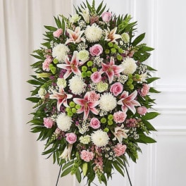 Standing floral spray with pink lilies, roses, and white mums on an easel
