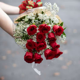 Bouquet of red roses with white baby's breath and a striped ribbon