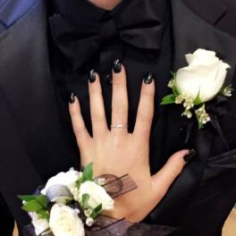 White rose boutonniere and matching wrist corsage with black ribbon on black tuxedo