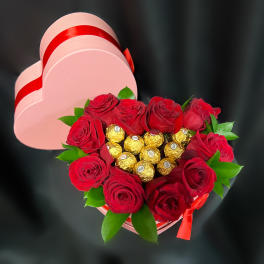 Heart-shaped box with red roses and gold-wrapped chocolates