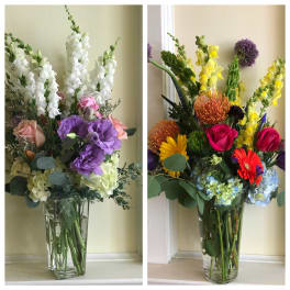 Two colorful mixed flower arrangements in clear glass vases