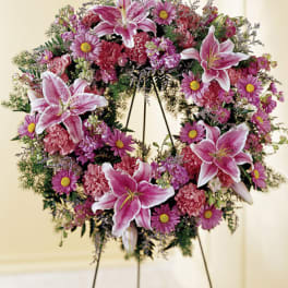 Pink lily and daisy wreath on a stand