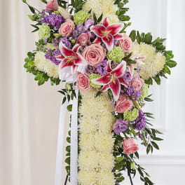 Standing floral cross with pink roses, lilies, and white mums