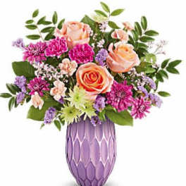 Mixed pink and peach flowers in a purple vase