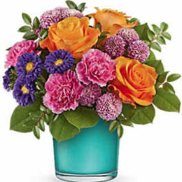 Bouquet of orange roses, pink carnations, and purple daisies in a blue vase