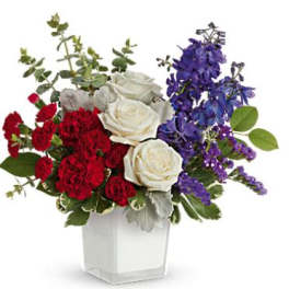 Bouquet of red and white roses with purple flowers in a clear vase